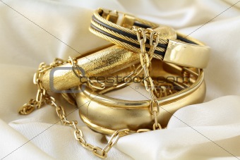 gold jewelry, bracelets and chains on silk