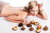 blond sexy girl eating pastry, she has right hand near her head