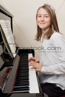 Happy young girl playing the piano