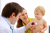 Lovely baby being checked by a doctor using a stethoscope 
