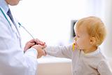 Interested baby stretching for stethoscope 
