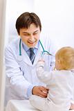 Pediatric doctor trying to examine baby 
