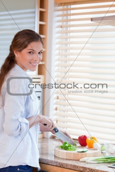 Portrait of a woman slicing pepper