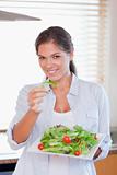 Portrait of a happy woman eating a salad