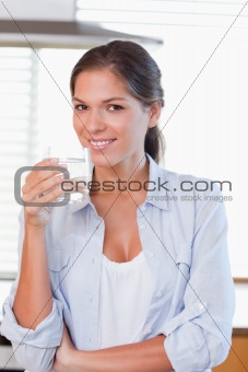 Portrait of a smiling woman holding a glass of water