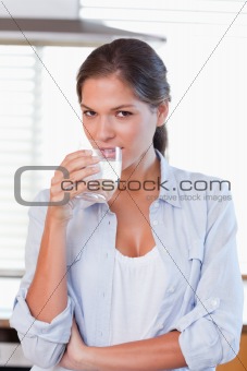 Portrait of a young woman drinking a glass of water