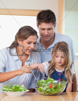 Portrait of a family preparing a salad
