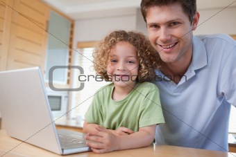 Happy boy and his father using a notebook