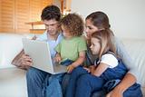 Focused family using a laptop