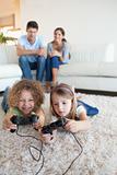 Portrait of children playing video games while their parents are watching