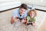 Smiling boy and his father playing video games