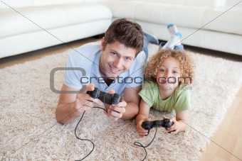 Smiling boy and his father playing video games