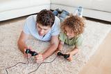 Focused boy and his father playing video games
