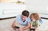 Cheerful boy and his father playing video games