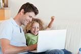 Cheerful boy and his father using a laptop