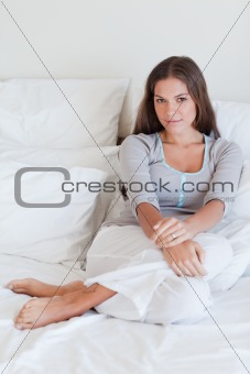 Portrait of a woman sitting on her bed