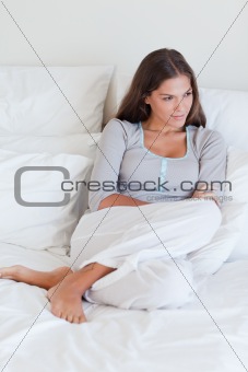Portrait of a young woman sitting on her bed