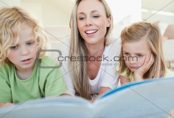 Mother reading magazine with her children