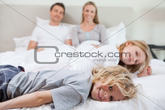 Family relaxing on the bed