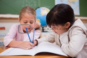 Happy schoolgirls doing classwork