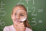 Schoolgirl looking through a magnifying glass