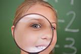 Close up of a schoolgirl looking through a magnifying glass