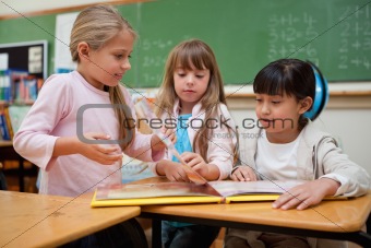Little schoolgirls reading a fairy tale to their classmate