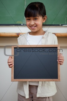 Portrait of a girl holding a school slate