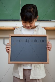 Portrait of a cute girl holding a school slate