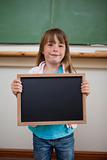 Portrait of a smiling girl holding a school slate