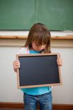 Portrait of a girl looking at a school slate