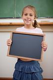Portrait of a happy girl holding at a school slate