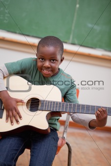 Portrait of a schoolboy playing the guitar