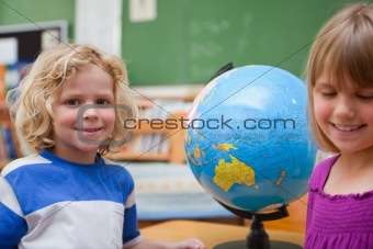 Young pupils posing in front of a globe