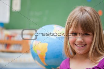 Schoolgirl posing in front of a globe