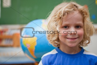 Schoolboy posing in front of a globe