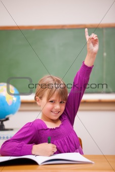 Portrait of a schoolgirl raising her hand
