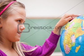 Close up of a cute schoolgirl looking at a globe
