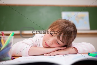Schoolgirl sleeping on a desk