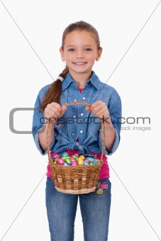 Portrait of a girl holding a basket full of Easter eggs