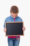Portrait of a young girl looking at a school slate