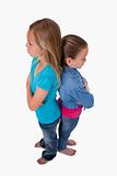 Portrait of two girls standing back to back