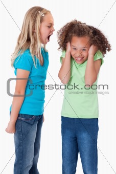 Portrait of an angry girl screaming at her friend