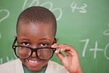 Smiling schoolboy looking over his glasses
