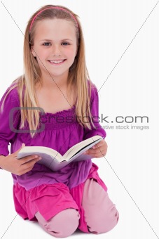 Portrait of a smiling girl reading a book