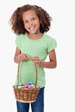 Portrait of a young girl holding a basket full of Easter eggs