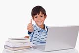 Boy using a notebook with the thumb up