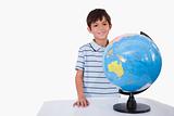 Smiling boy posing with a globe
