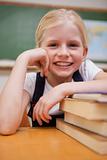 Portrait of a smiling girl leaning on books