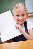 Portrait of a happy girl showing her school report